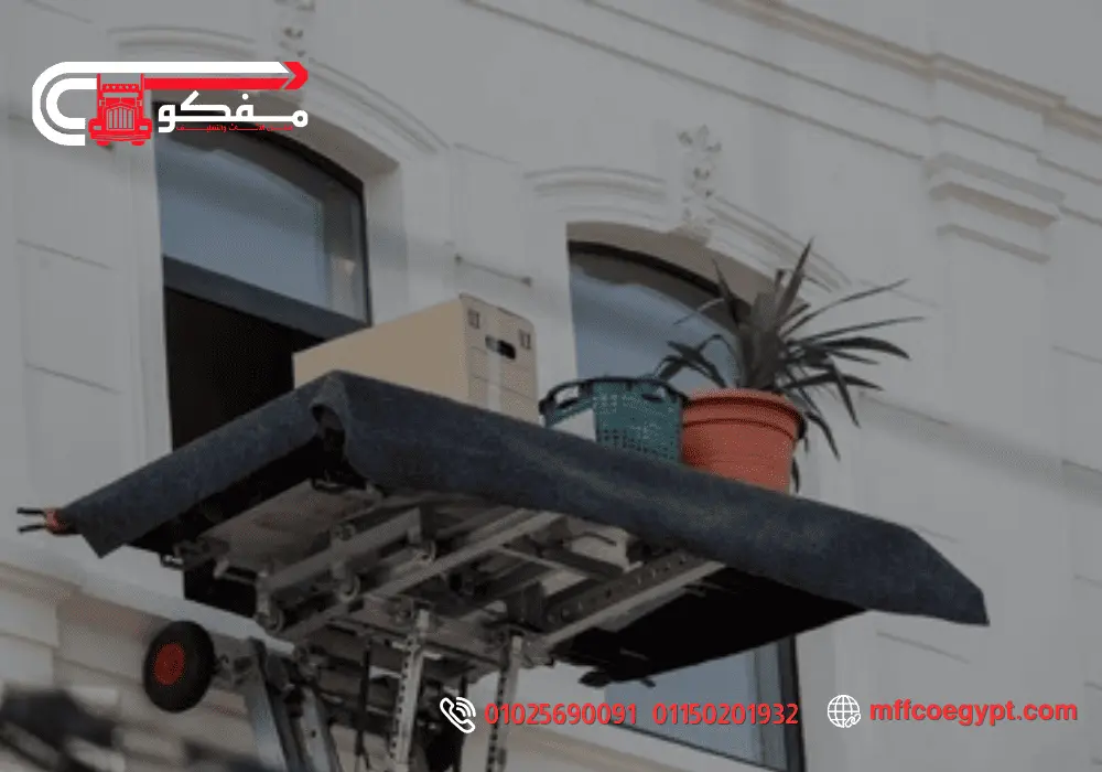 ارخص ونش رفع الاثاث في مصر الجديدة - خدمة آمنة وفعالة للنقل ونش رفع اثاث يستخدم لنقل صناديق ونباتات من الطابق الثاني في مبنى أبيض بمصر الجديدة.
